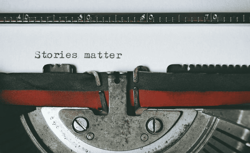 The words ‘Stories matter’ written on a black and red typewriter.