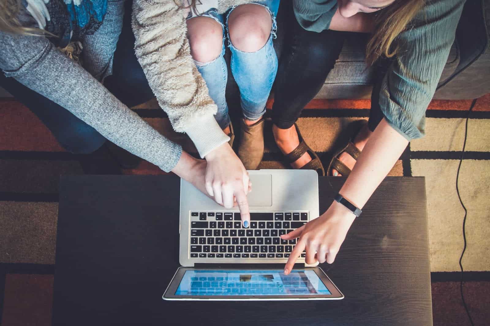 people pointing at a project on a laptop screen