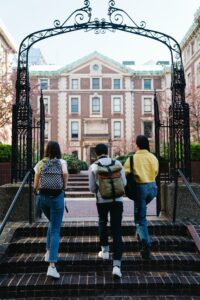 higher education marketing students walking up stairs to enter their college campus